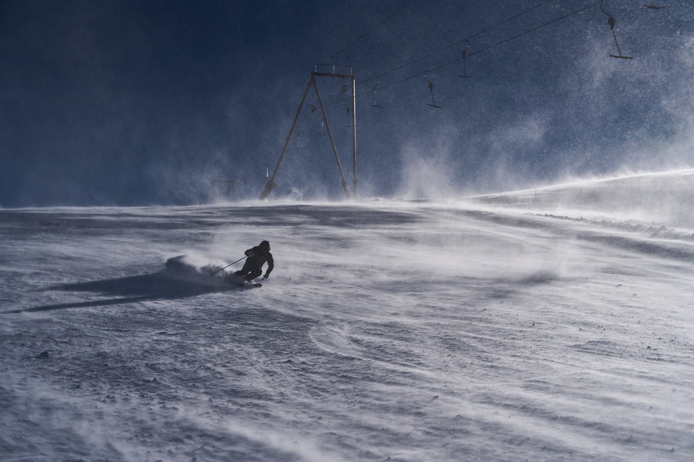 Skier carving in windy alpine conditions