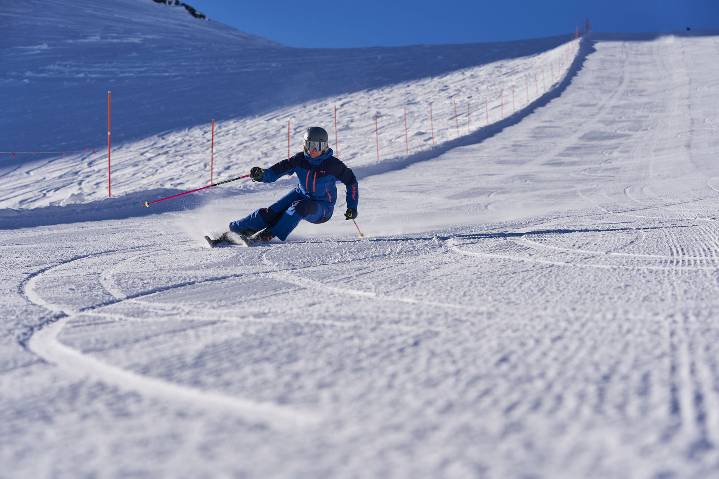 Skier carving turns on groomed slope